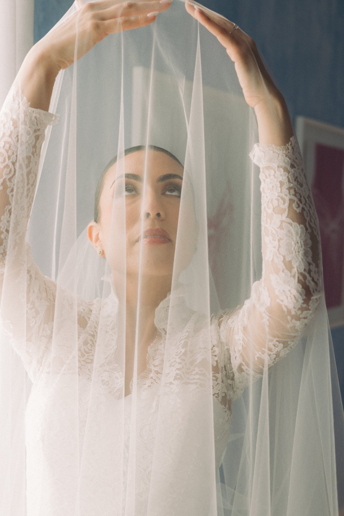 Editorial bridal portrait with veil framed in an arched pose