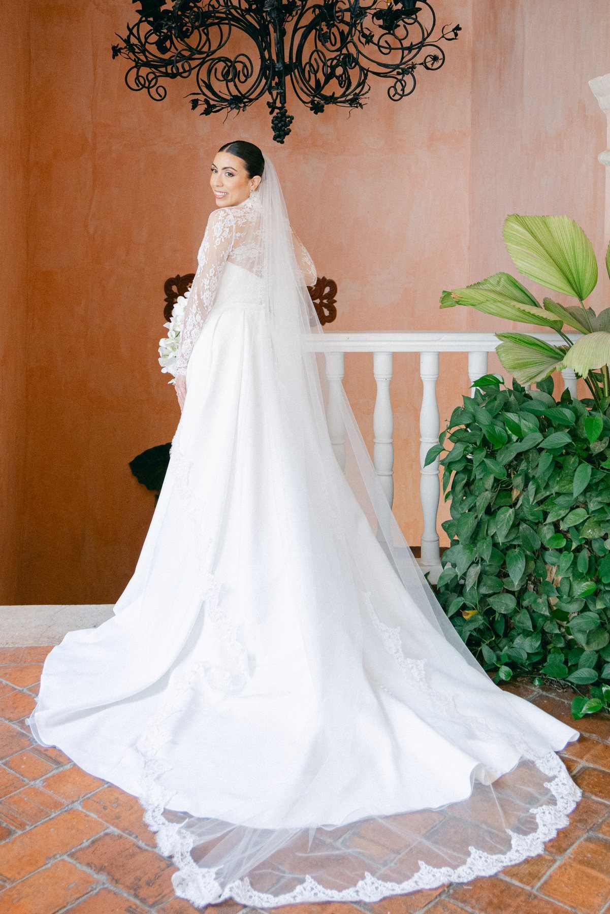 Editorial wedding portrait on a colonial staircase beneath a chandelier