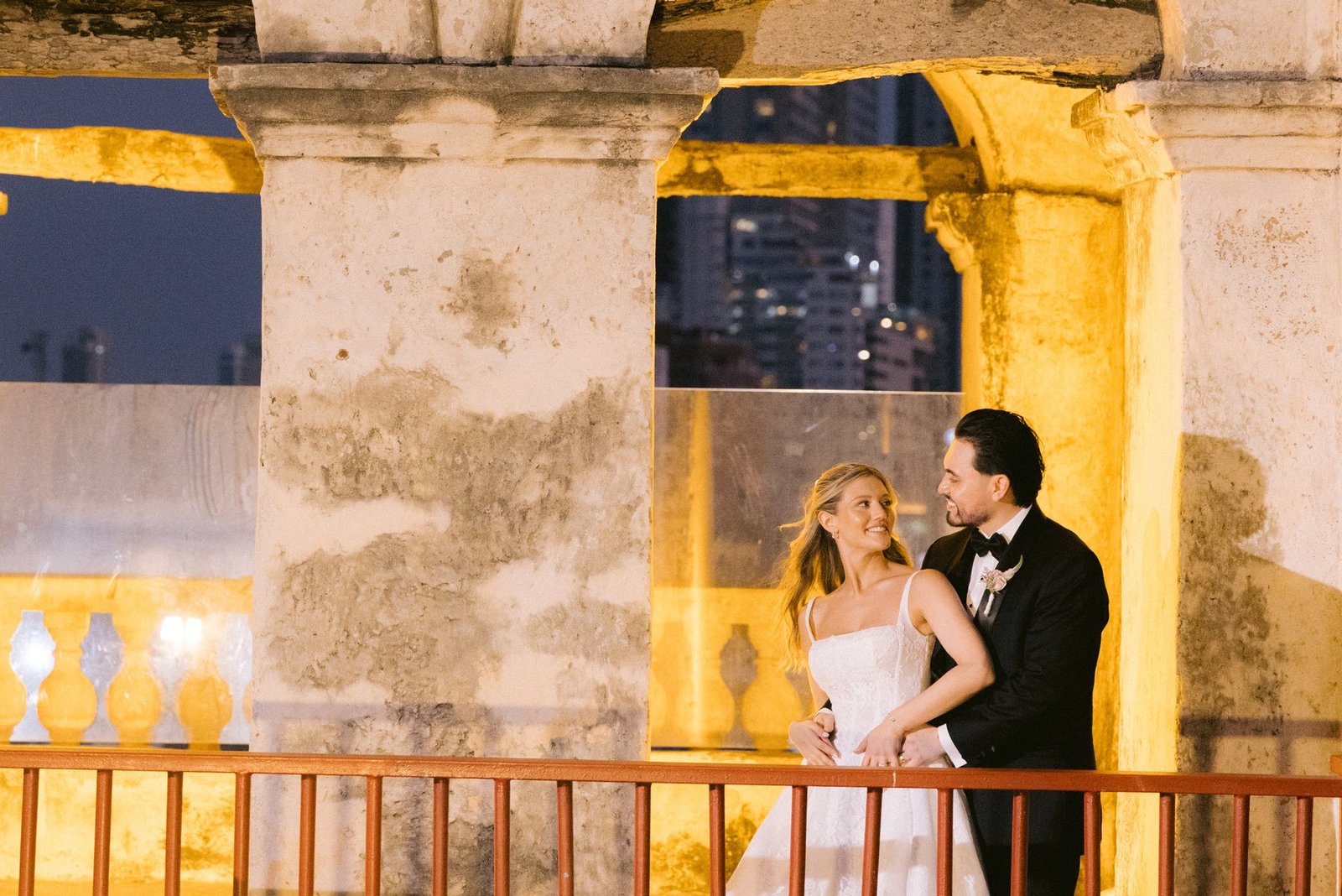 Editorial couple portrait beneath a jungle archway, destination wedding