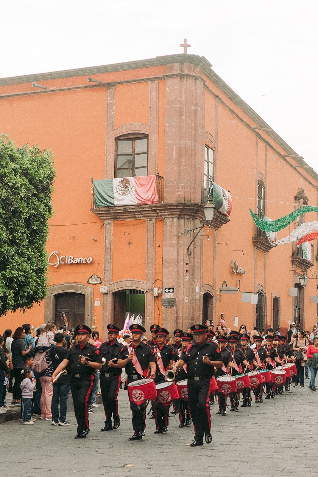 A traditional street parade in front of a colonial building