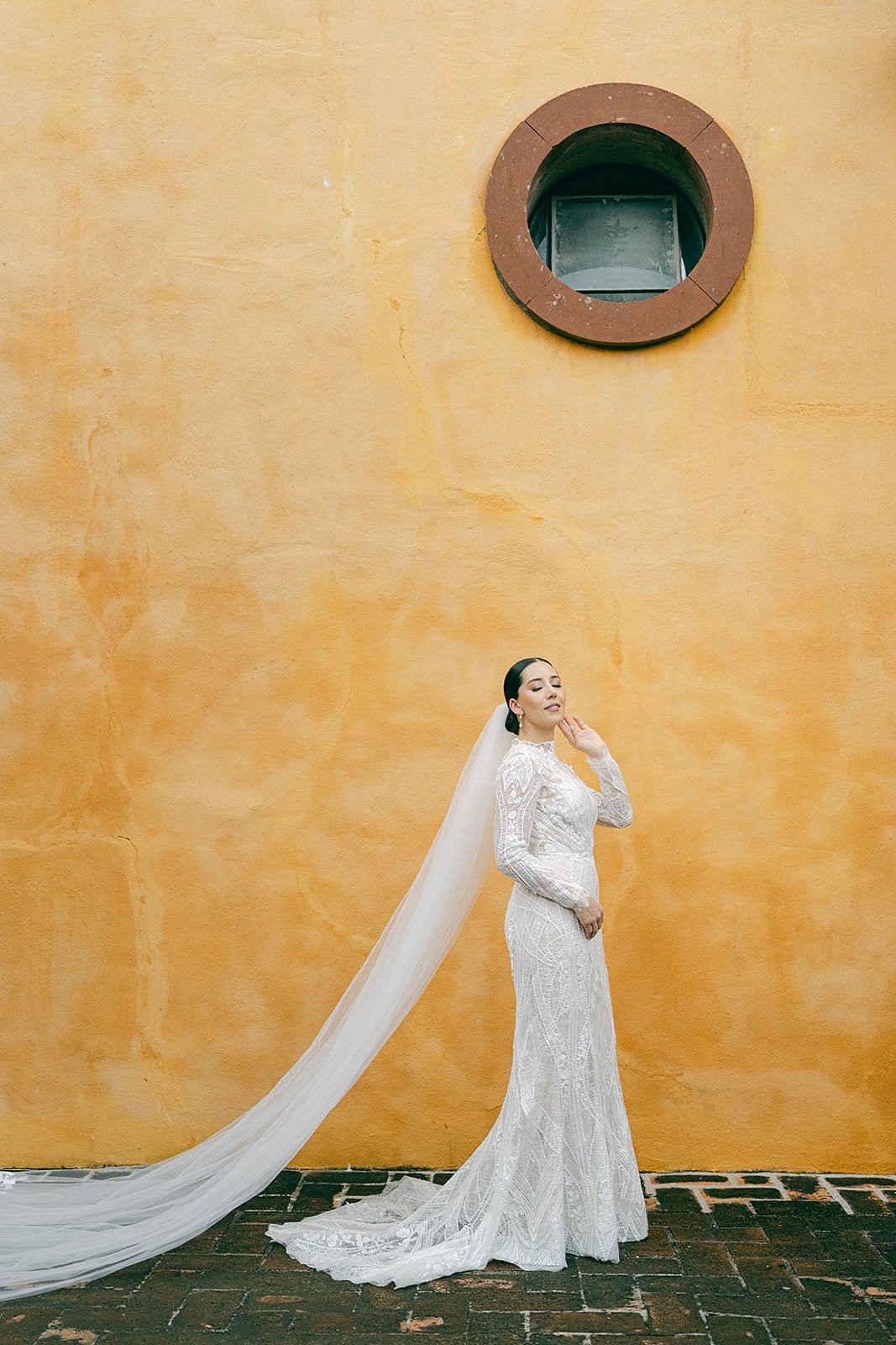 Cari against a terracotta wall with a circular window